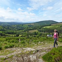 Wanderin bestaunt die waunderbar grüne Landschaft Irlands