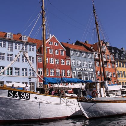 Weißes historisches Segelboot S.A.98 im Hafen Nyhavn mit bunten Bürgerhäusern aus dem 17. Jahrhundert in Rot, Gelb und Blau am Kanal.