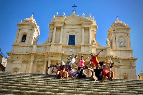 Cyklister vid kyrka i Noto