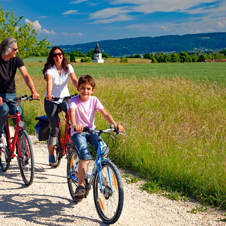 Familie radelt am Bodenseeradweg in der Landschaft